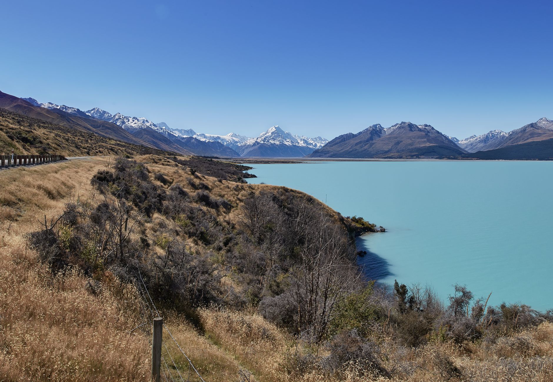 Serene view of Lake Pukaki and the Southern Alps under a clear blue sky, Canterbury, New Zealand.